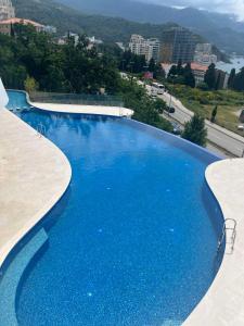 a large blue swimming pool with a view of a city at Mare Sea View Suites ,One Bedroom 305 in Bečići