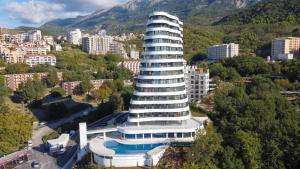 a large building with a pool in front of a city at Mare Sea View Suites ,One Bedroom 305 in Bečići