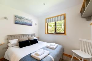 a bedroom with a bed with towels on it at L56 - Seaglass in Truro +10 photos