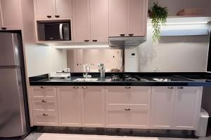 a kitchen with a sink and a refrigerator at Santorini Urban Studio • conforto e estilo in Londrina +1 photo