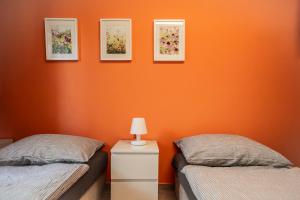 two beds in a room with orange walls at Ferienstudio Traunsee in Gmunden