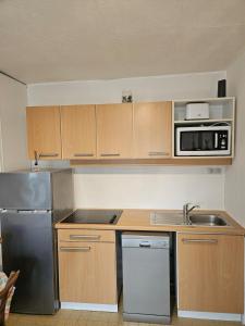 a kitchen with stainless steel appliances and wooden cabinets at Le 61 Roosvelt in Amiens