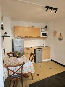 a small kitchen with a table and a refrigerator at Le 61 Roosvelt in Amiens