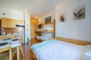 a bedroom with a bed and a sink and a kitchen at Vista piste da sci - Aprica Centro - Piste a 2 min, Wifi in Aprica +13 photos