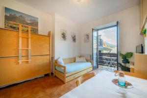 a room with a table and a bed and a window at Vista piste da sci - Aprica Centro - Piste a 2 min, Wifi in Aprica