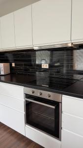 a kitchen with a stove and white cabinets at Ocean View Guesthouse in Borgarnes
