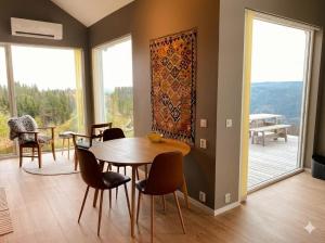 a dining room with a table and chairs and a large window at Large cabin with panoramic wiews in Ål, Hallingdal in Al