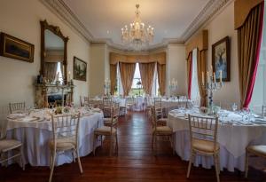 a room filled with tables and chairs with a chandelier at Moyvalley Hotel & Golf Resort in Enfield