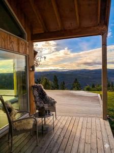 a deck with two chairs and a table on a house at Large cabin with panoramic wiews in Ål, Hallingdal in Al
