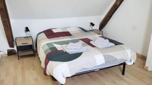 a bedroom with a bed with two night stands and two lamps at Gîte de l'Aubinière in Brissac-Quincé