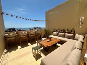 a living room with a couch and a table on a roof at Arya Imsouane in Imsouane