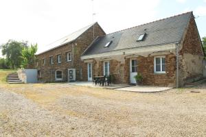 an old brick building with a table in front of it at Gîte de l'Aubinière in Brissac-Quincé