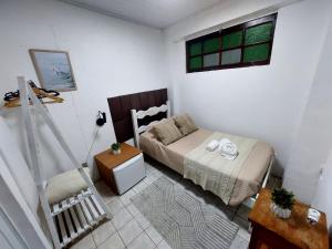 a small bedroom with a bed and a window at Pousada Casa da Pedra in Búzios