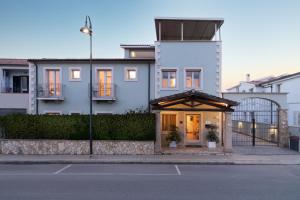 a white house with a gate on a street at Marin Hotel in Pula