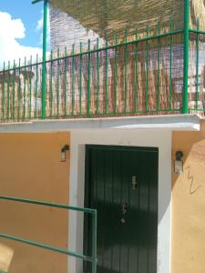 a green door on a building with a balcony at The stone house in Doukádes