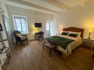 a bedroom with a bed and a table and chairs at La Maison de Lyon in Saint-Laurent-de-Céris