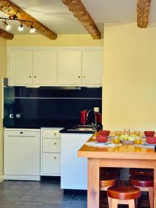a kitchen with white cabinets and a wooden table at Ribeira da Janela Paradise View in Porto Moniz