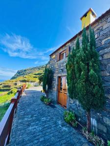 a stone building with a tree in front of it at Ribeira da Janela Paradise View in Porto Moniz