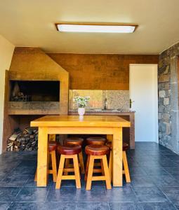 a kitchen with a wooden table and stools at Ribeira da Janela Paradise View in Porto Moniz