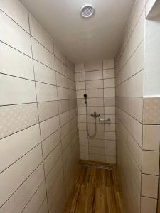 a bathroom with a shower with white tiled walls at Komorník Residence 14 in Kunžak +14 photos
