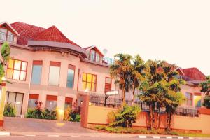 a large white building with trees in front of it at Legend Hotel Kigali in Kigali +16 photos