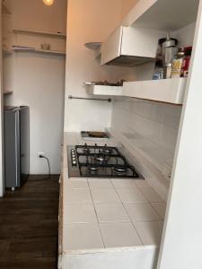 a white kitchen with a stove top oven at Rachana Guest House in Mestre