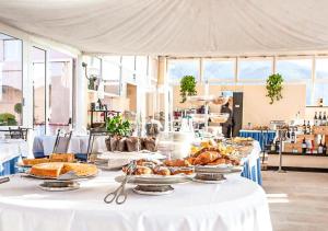 a table with plates of food on top at Hotiday Arenzano Pineta in Arenzano