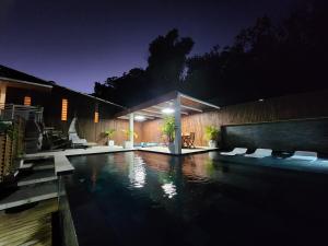 a house with a swimming pool at night at Cap'vanille in Saint-Philippe
