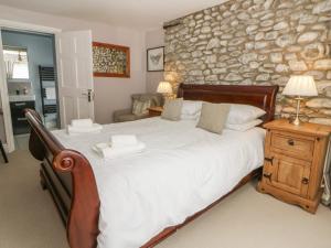 a bedroom with a large bed and a stone wall at Dewi Villa in Aberaeron