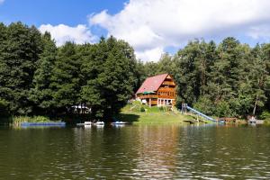 a log cabin on the shore of a lake at Komorník Residence 14 in Kunžak
