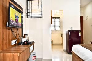 a room with a bed and a tv on a wall at SGR Luxury Homes in Kammasandra