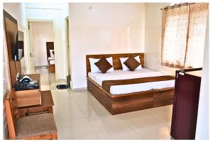 a bedroom with a bed and a television in a room at SGR Luxury Homes in Kammasandra