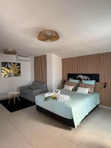 a bedroom with a large bed and a chair at Cap'vanille in Saint-Philippe +24 photos