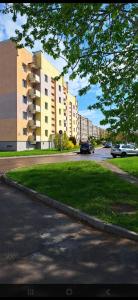 a street with cars parked in front of a building at Viktorija Apartament in Liepāja