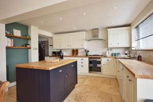 a kitchen with white cabinets and a wooden counter top at Spacious Free Parking 5 Mins from City Centre in Hereford