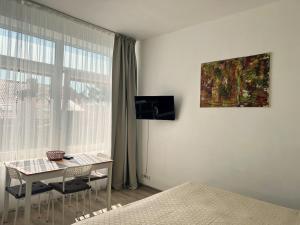 a bedroom with a desk and a window with a table at Studio Relax in Nida