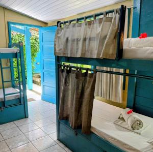 a room with two bunk beds and a door at Casa Swell Hostel in Fernando de Noronha