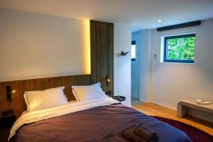 a bedroom with a large bed with a window at Aplusstudio in Zottegem