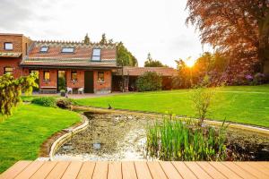 a house with a pond in front of a yard at Aplusstudio in Zottegem