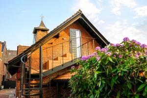 a brick house with a staircase and purple flowers at Aplusstudio in Zottegem +33 photos
