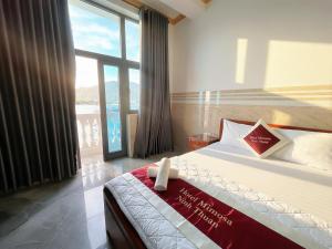a bedroom with a bed and a large window at Mimosa 8 Hotel - Ninh Chử in Ninh Hải