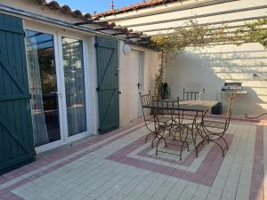 a patio with a table and chairs on a patio at La dependance in Saint-Gilles