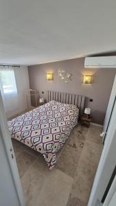 a bedroom with a bed and two lights on the wall at La dependance in Saint-Gilles