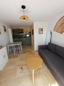 a living room with a couch and a table at La dependance in Saint-Gilles