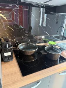 two frying pans sitting on a stove in a kitchen at RK chic Apartments in Colombaro +10 photos