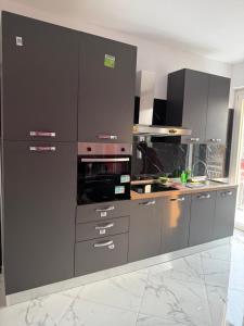 a kitchen with gray cabinets and a counter top at RK chic Apartments in Colombaro
