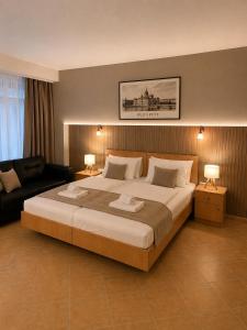a bedroom with a large bed and a couch at Esprit Residences Budapest in Budapest +54 photos