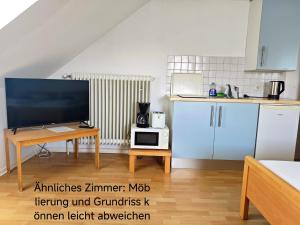 a kitchen with a television and a table with a microwave at Haus Marinus in Puttgarden