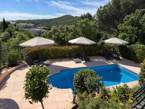 a swimming pool with umbrellas and chairs next to a resort at Villa sainte maxime golfe de Saint Tropez in Sainte-Maxime
