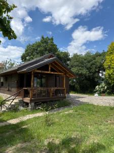 a log cabin with a porch and a yard at Vila Kadiu in Klos